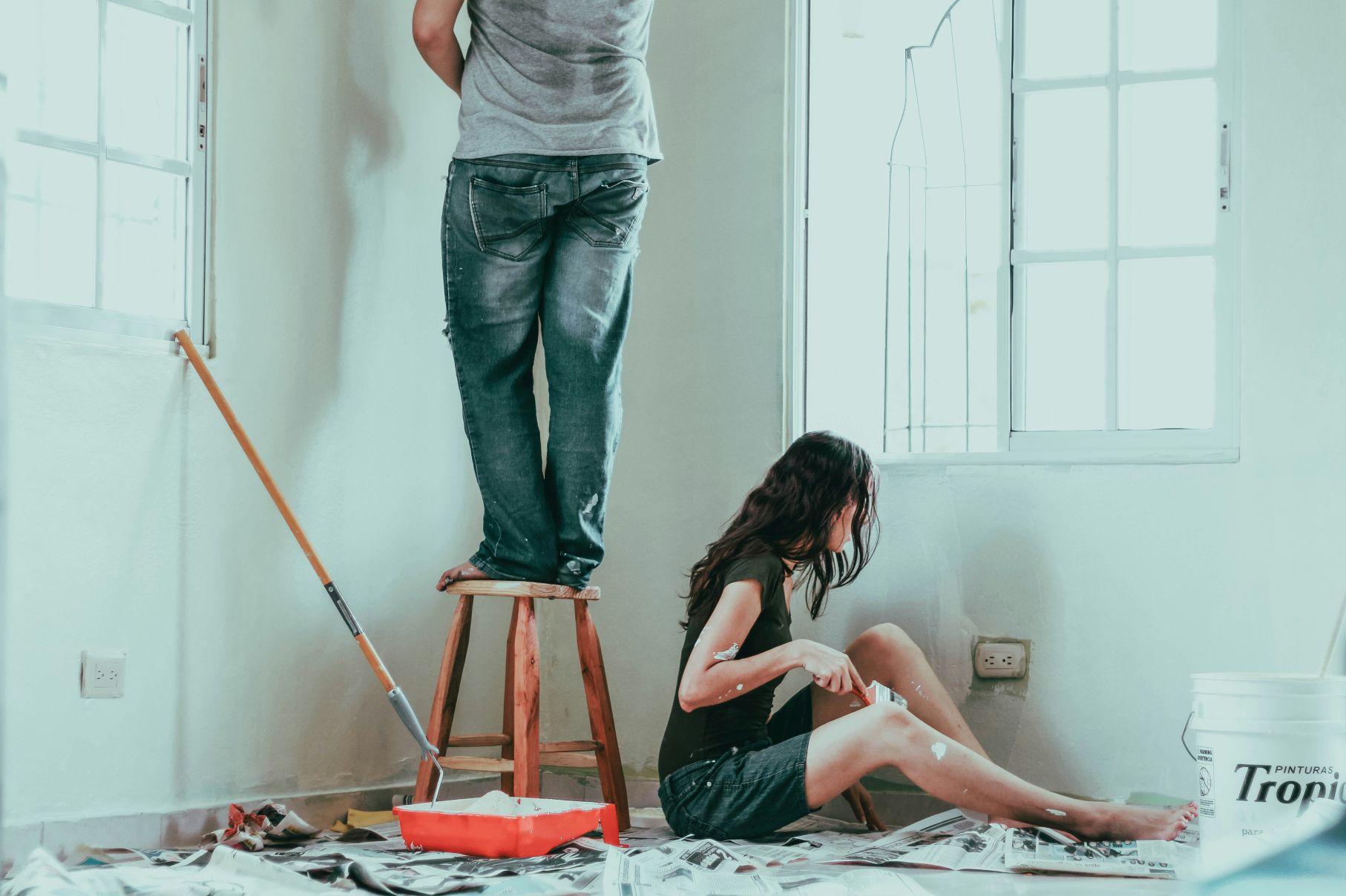 Couple painting their Central Coast home during renovation — renovate vs move decision