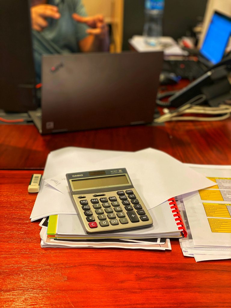SMSF property loan paperwork with calculator and coffee on desk