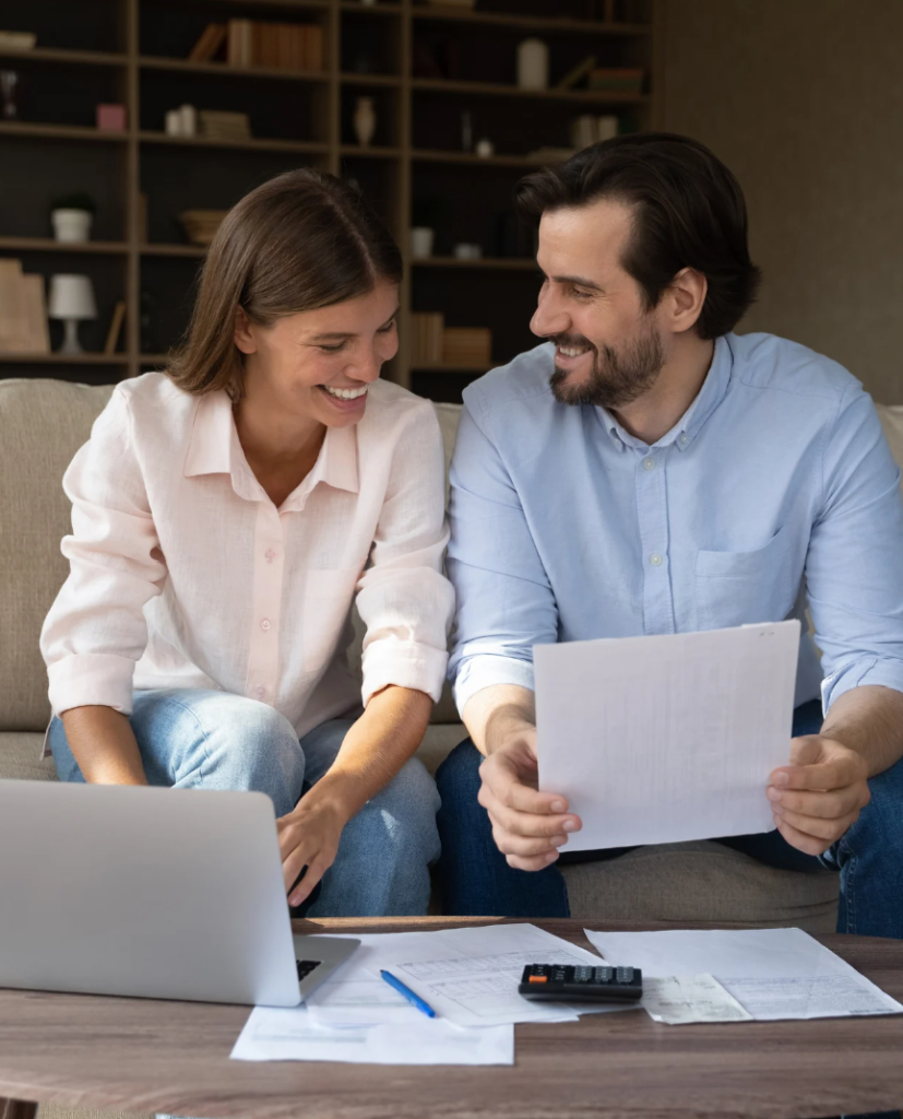 Happy middle-aged couple reviewing SMSF property loan documents at home