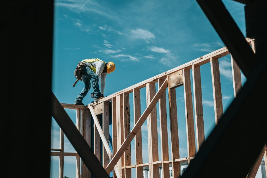 Builder standing on roof frame during new home construction Central Coast