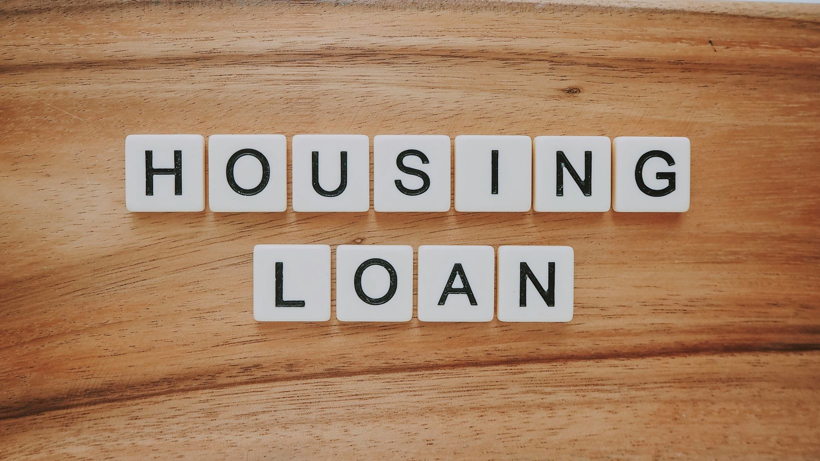 Scrabble tiles spelling “housing loan” representing the home loan process for first home buyers