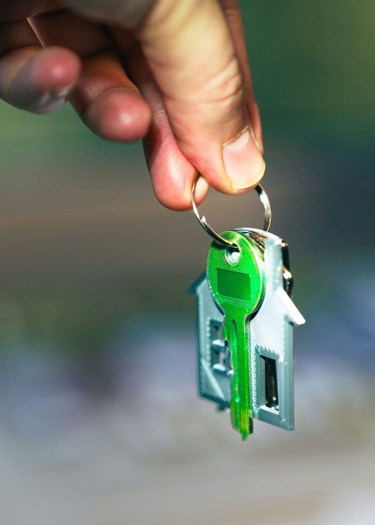 Hand holding house key after new home build completion Central Coast