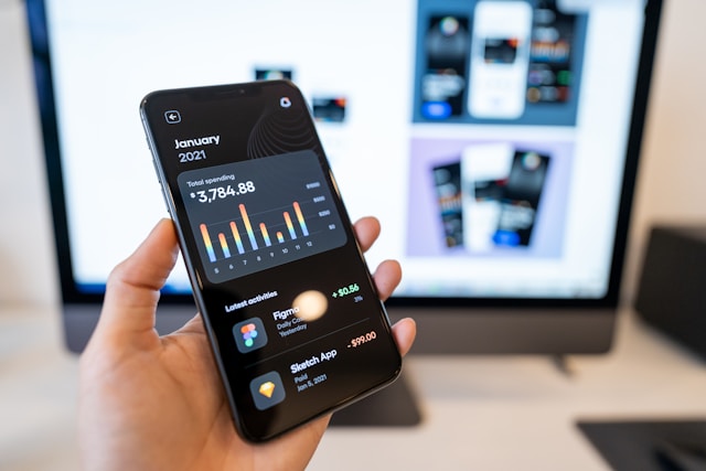 Person holding a smartphone with a banking app open while reviewing income for a home loan application