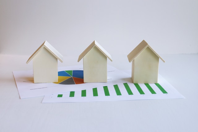 Model houses on financial charts representing home equity and investment property ownership