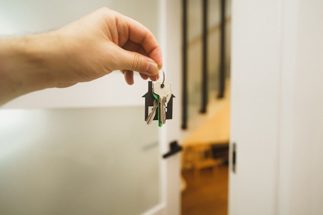 Homeowner holding house keys representing refinancing a home loan