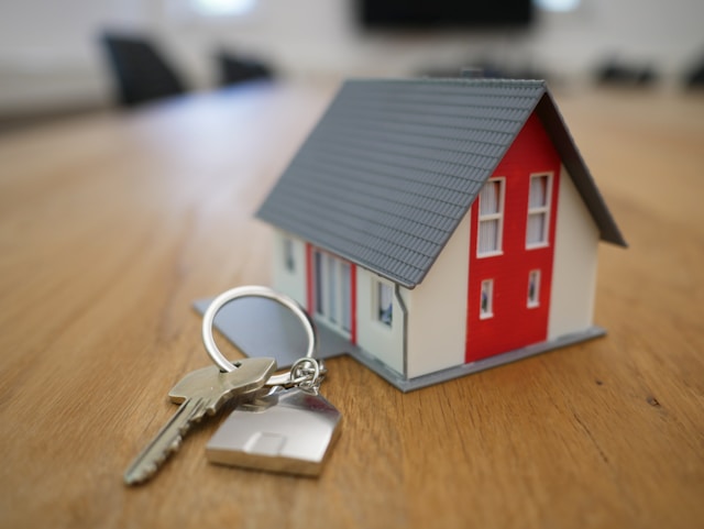House model and keys representing reviewing or refinancing an existing home loan